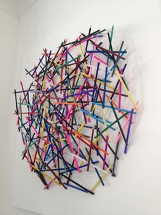 a pile of sticks sitting on top of a white wall