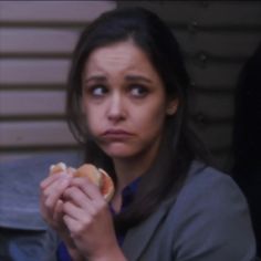 a woman holding a hot dog in her hand