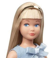 a doll with blonde hair and blue eyes is wearing a light blue dress that has a bow on it's head