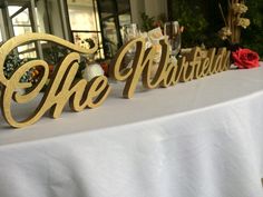 the table is covered with white linens and gold letters that spell out the word, she married