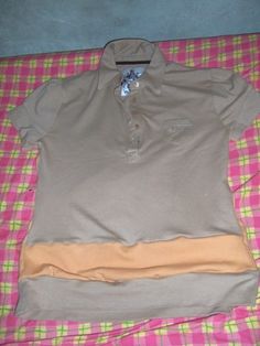 a polo shirt laying on top of a pink and green checkered blanket