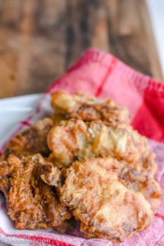 some fried food is on a red and white napkin