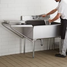 a man is washing his hands in the sink while standing next to a wall mounted faucet