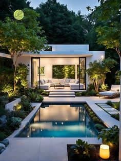 an outdoor living area with a pool and patio furniture in the background at night time