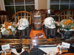 a motorcycle themed table setting with skulls on the top and flowers in vases next to it