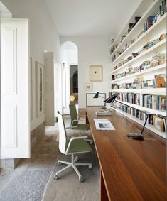 an office with bookshelves, desk and chair in the middle is featured in this magazine