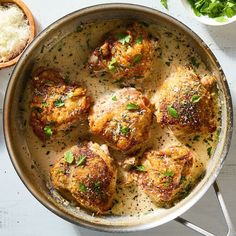 a pan filled with meatballs covered in gravy and garnished with parsley