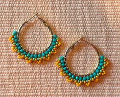 Beautifully beaded hoop earrings with seed beads, using a Native brickstitch pattern.  These earrings are hypoallergenic gold and silver hoops and are 1 inch in diameter.  The yellow with teal on the gold hoops are 2 inches in diameter. Hoops Beaded Earrings, Gold Hoop Earrings With Tiny Beads, Gold Small Hoop Earrings With Spacer Beads, Gold Small Hoop Earrings With Tiny Beads, Yellow Beaded Small Hoop Earrings, Small Yellow Beaded Hoop Earrings, Yellow Beaded Round Hoop Earrings, Yellow Beaded Small Hoop Jewelry, Handmade Yellow Hoop Earrings