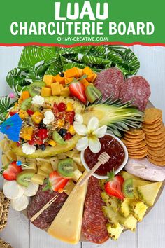 a platter filled with different types of cheeses and fruit on top of a white table