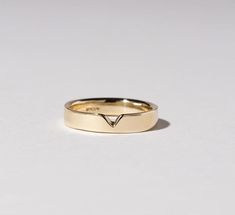 a yellow gold ring with a v on it