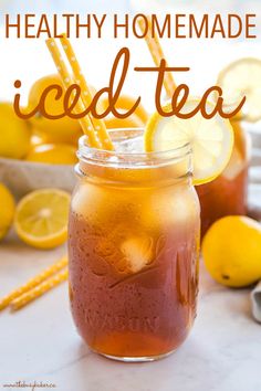 a mason jar filled with iced tea next to lemons