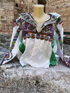 This is a lovely and unique, handmade vintage blouse. It is made of linen and is decorated with hand embroidery and beads. Every single detail and decor is handmade. Many work hours spent in manufacturing this blouse. It was made in the 1960's or 1970's. it is kept in a very good condition, without damages. Eye-catching design and pattern, unique blouse made by the women by their own who lived in the village of Labunista, near the Ohrid Lake. It is a light weight, smooth blouse made of linen. Lo Folk Style Embroidered Linen Top, Embroidered Linen Folk Tops, Folk Style Multicolor Embroidered Peasant Top For Festivals, Folk Style Embroidered Peasant Top For Festivals, Folk Style Peasant Top With Multicolor Embroidery For Festival, Bohemian Linen Top With Floral Embroidery, Green Linen Bohemian Blouse, Green Linen Bohemian Top, Bohemian Long Sleeve Linen Peasant Top