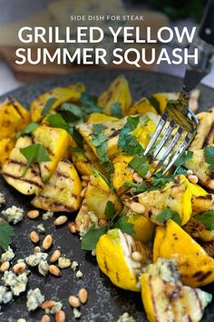 grilled yellow squash with feta cheese and pine nuts on a black platter