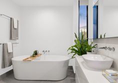 a white bath tub sitting next to a sink in a bathroom