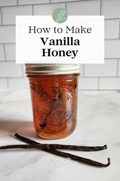 a jar filled with vanilla honey sitting on top of a counter next to two cinnamon sticks