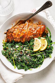 a white plate topped with meat and greens