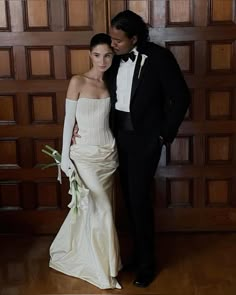 a man in a tuxedo standing next to a woman in a wedding dress