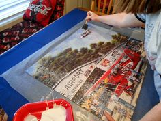 a woman is painting a picture on a table with white frosting in front of her