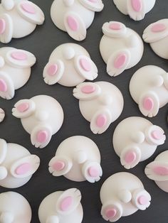 there are many white and pink teddy bears on the table together in this photo, they look to be made out of fondant