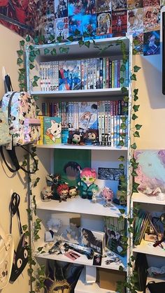 a book shelf filled with lots of books next to a wall covered in anime posters