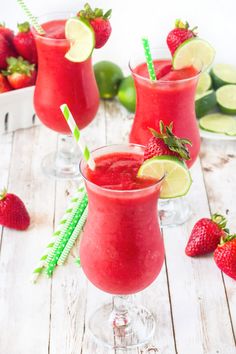 two glasses filled with watermelon and limeade next to strawberries