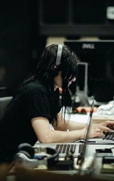 a woman wearing headphones using a laptop computer