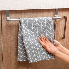 a hand is holding onto a towel on a rack