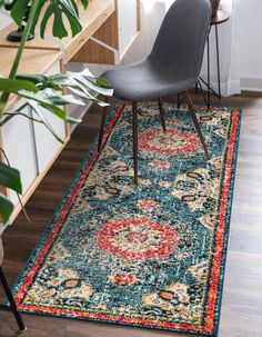 an area rug with a chair and plant in the corner, next to a desk