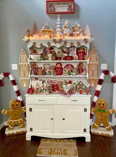 a white hutch with gingerbread decorations and ginger cookies on the top, along with other ginger - themed items