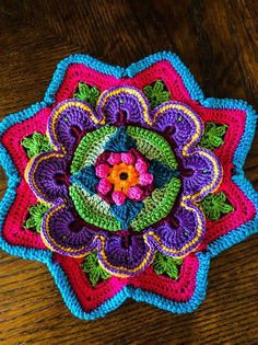 a crocheted flower on a wooden table