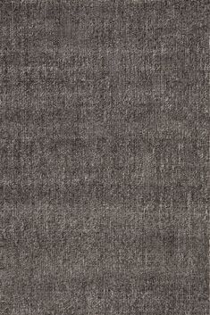 an area rug that has been made with dark gray wool and is very soft to touch