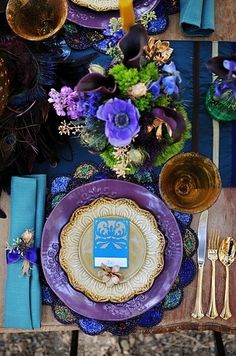 the table is set with purple and gold plates