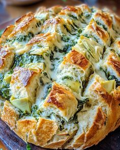 a cheesy bread dish with spinach and cheese in it on a cutting board