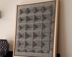 a wooden frame sitting on top of a shelf next to a vase