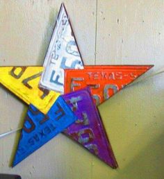 a multicolored star hanging from the side of a wall with letters on it