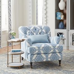 a blue and white chair sitting in front of a mirror on top of a rug