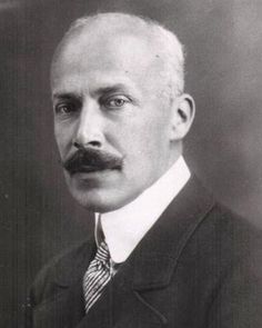 an old black and white photo of a man in a suit with a moustache