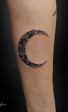 a black and white tattoo on the leg of a woman with a crescent moon design