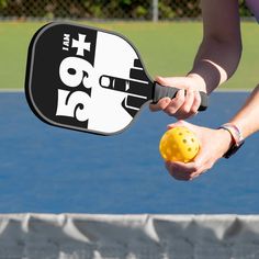 a person holding a tennis racquet with a yellow ball in front of them