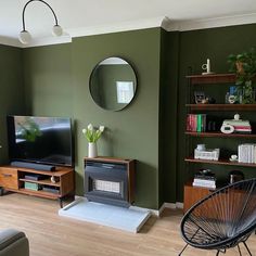 a living room filled with furniture and a flat screen tv sitting on top of a wooden shelf