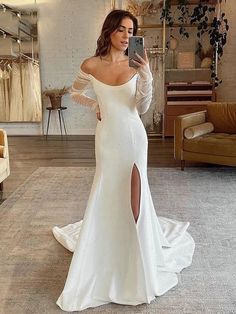 a woman is taking a selfie in her wedding dress while wearing a white gown