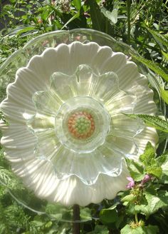 a glass flower sitting on top of a lush green field