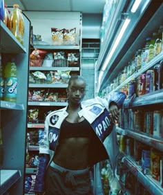 a woman is standing in the aisle of a grocery store with her shirt open and she's holding a bag