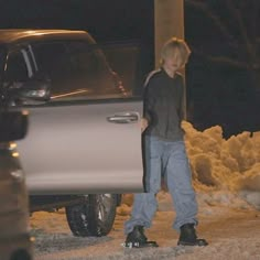 a man standing next to a parked silver truck