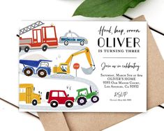 a birthday card with trucks and construction vehicles on it, next to a green leaf