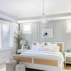 a bedroom with white bedding and wicker baskets on the floor next to it