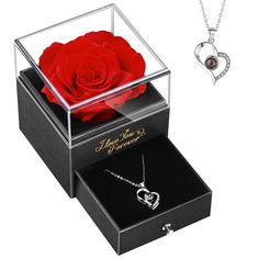 a red rose in a glass box next to a necklace and pendant with the words i love you forever written on it