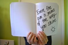 someone holding up an open book with writing on it that says, even the sun is views of the way you smile