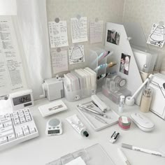 a white desk topped with lots of office supplies