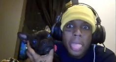 a man wearing headphones holding a dog in front of him with his tongue out